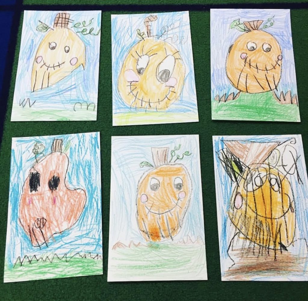 Children's art using a pumpkin directed drawing worksheet.