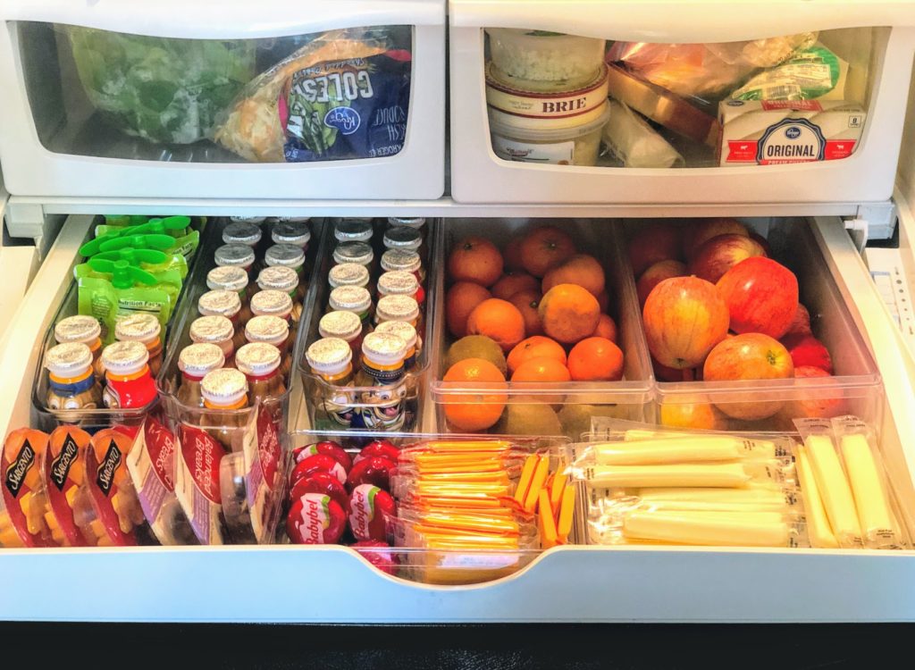 Have kids? This fridge snack drawer organization hack is the perfect solution for easy-access to healthy foods at kid-height! Using inexpensive refrigerator storage containers, you can create an organized space that makes it easy for all to see what snacking options are on hand. 