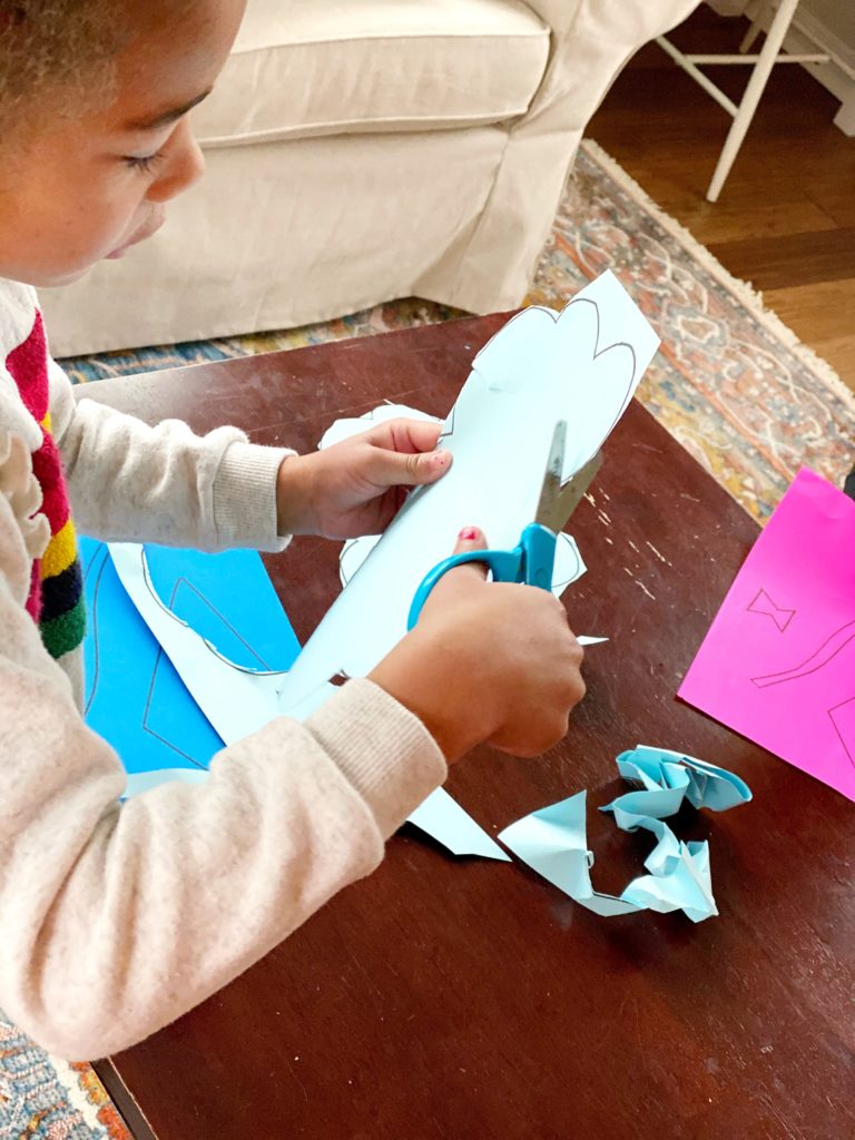 Cutting out spring kit craft template to develop fine motor skills.